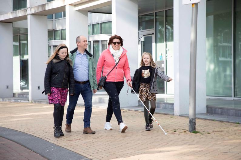 Gezin op straat moeder met taststok